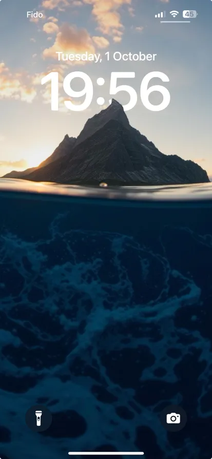 Ocean scene with sunset, clouds, and a dramatic mountain.