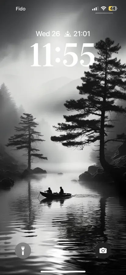 The scene is of a river in black and white. The trees around it are covered in mist and fog.