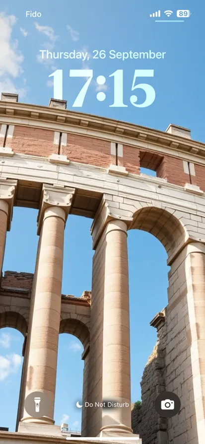 Tall ancient columns support an archway under a blue sky.