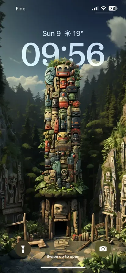 Colorful totem poles at Vancouver High, showcasing native animals and symbols amidst lush trees under a blue sky.