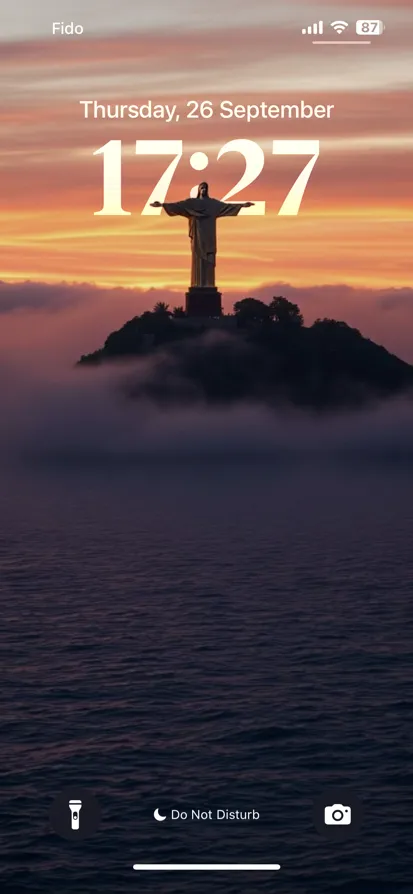 A stunning sunset landscape featuring a statue on a foggy hill.