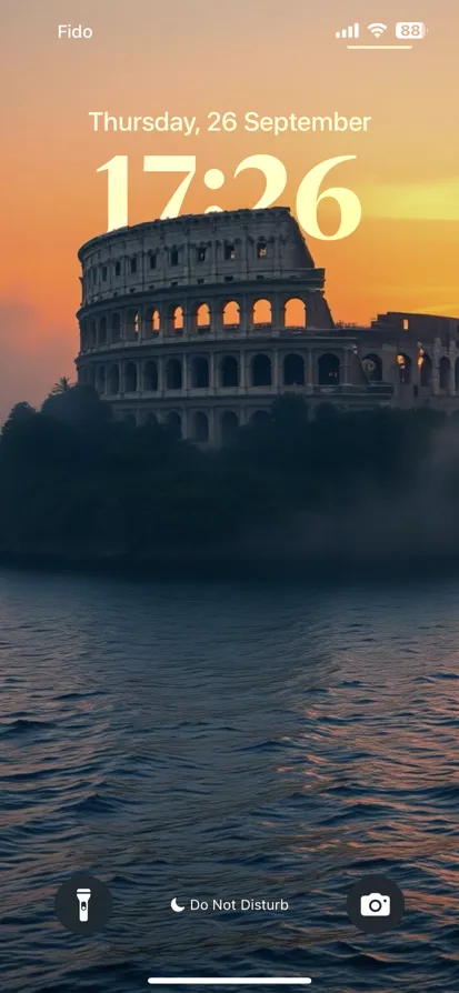 A serene coliseum-like structure surrounded by water and mist at sunset.