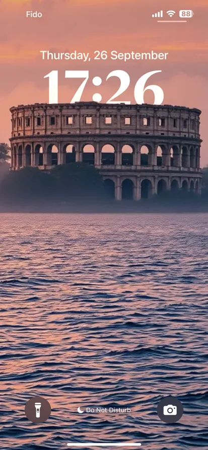 A classical coliseum on an island during a vibrant sunset.