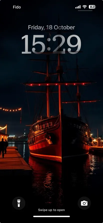 A beautiful ship docked at a harbor, illuminated by warm lights at night.