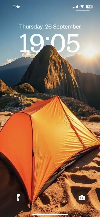 An orange tent glows at sunset against a mountain backdrop.