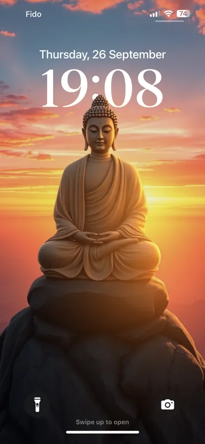 A serene Buddha statue illuminated by a golden sunset.