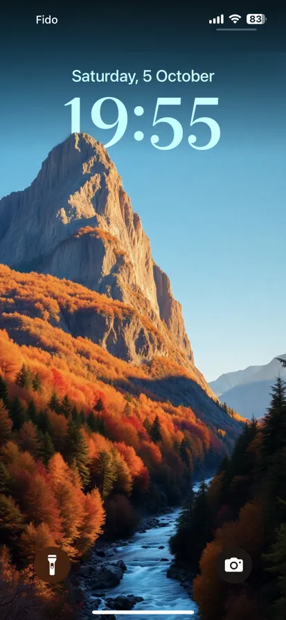 Tranquil fall scene with a sunlit mountain and vibrant forest.