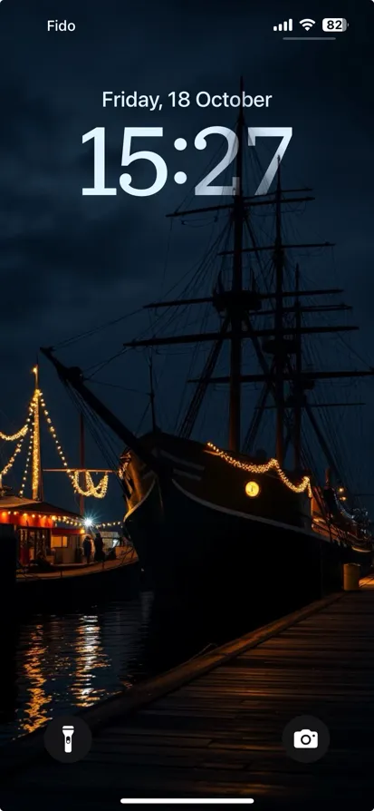 A dark harbor scene with a lit ship and tranquil reflections.