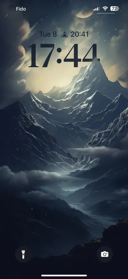 Several mountains covered in snow under a moonlit foggy night.
