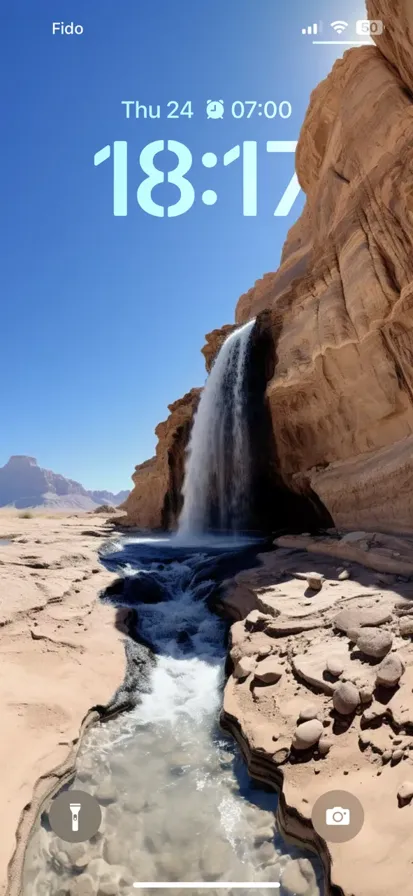 A breathtaking view of a waterfall flowing through a desert landscape with majestic mountains in the background. - depth effect wallpaper